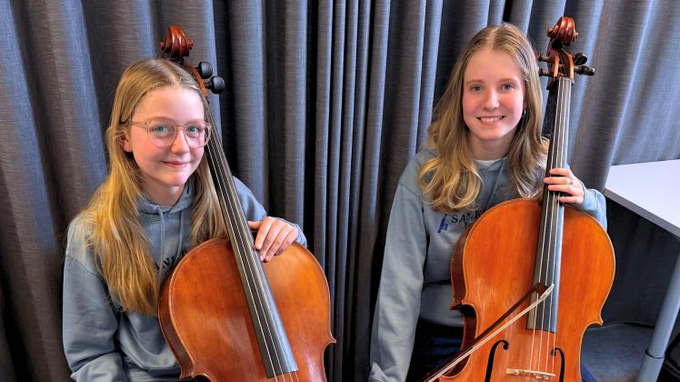 Et billede af Frieda og Christine, der sidder med hver deres cello